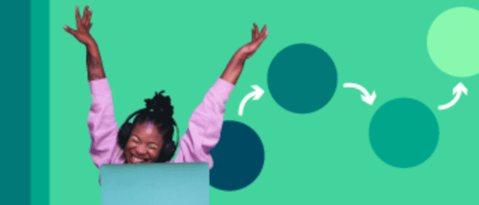 Mujer en un portátil sonriendo con los brazos arriba